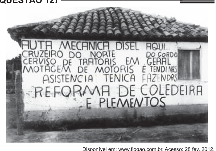Fotografia em preto e branco de uma parede com anúncios pintados à mão de serviços mecânicos.