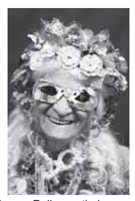 Fotografia em preto e branco de uma pessoa idosa sorrindo, com adereço de flores na cabeça e óculos escuros decorados.