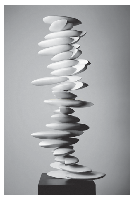 Fotografia em preto e branco de escultura branca formada por discos ovais empilhados sobre pedestal escuro.