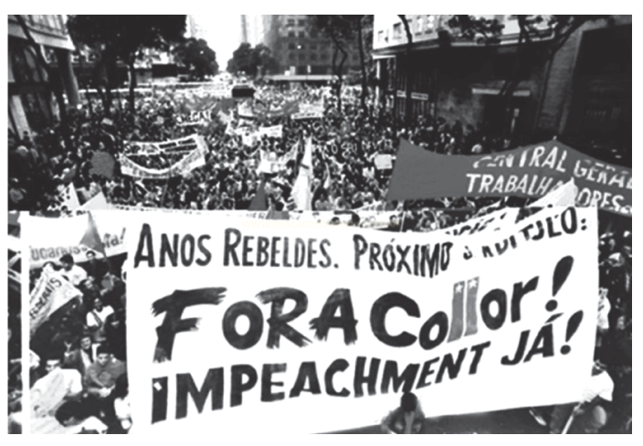 Fotografia em preto e branco de uma multidão em manifestação de rua com faixas contra Collor.